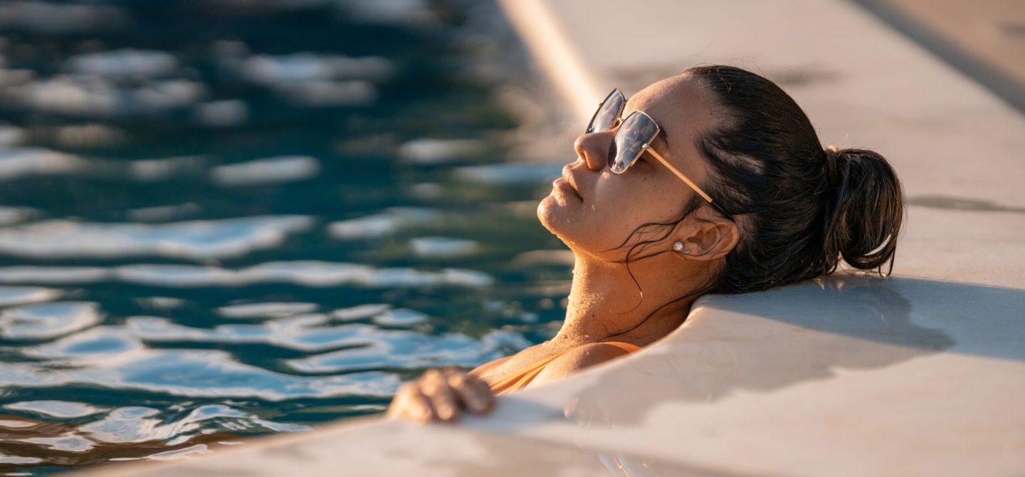 Resident enjoying the heated outdoor pool at 18 Brownlow, a private summer oasis in Midtown Toronto.